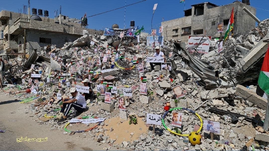 به همراه تصاویرنمایشگاه عکس کودکان و زنان شهید فلسطینی بر روی خرابه‌های خانه‌های مسکونی غزه 2